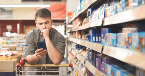 Hombre comparando precios de productos en un supermercado