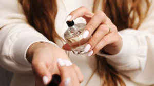 Persona aplicándose perfume en la muñeca